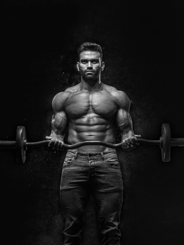 Black and white portrait of a muscular man lifting weights, showcasing strength and fitness.