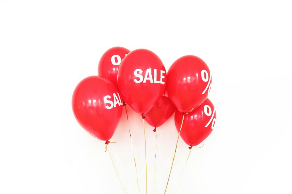 pexels-photo-3905873-3905873 Vibrant red balloons displaying sale text and percentage signs, ideal for promotions.
