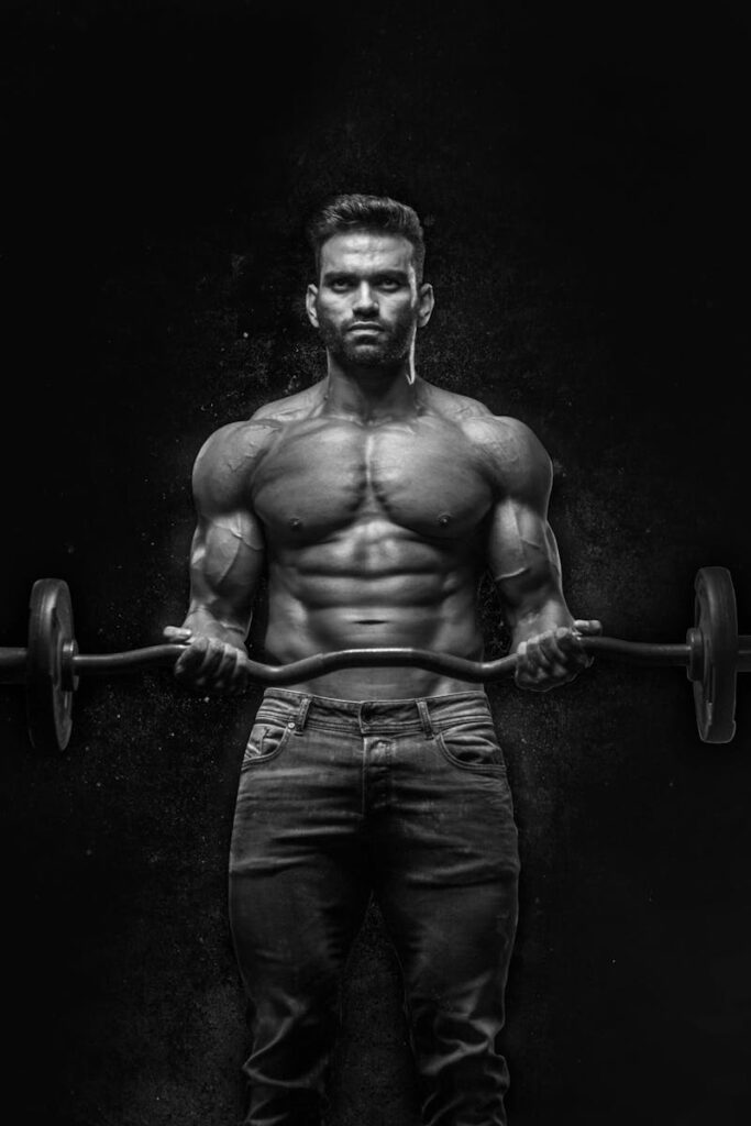 Black and white portrait of a muscular man lifting weights, showcasing strength and fitness.