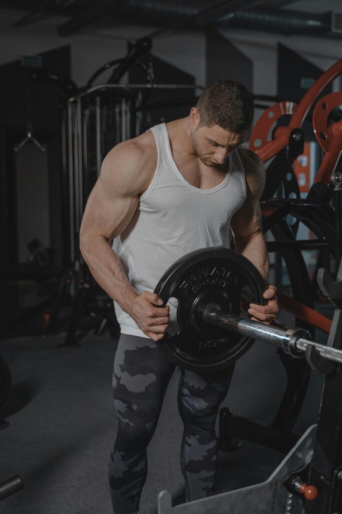 Strong muscular man in gym lifting weights. Perfect for fitness and strength training concepts.