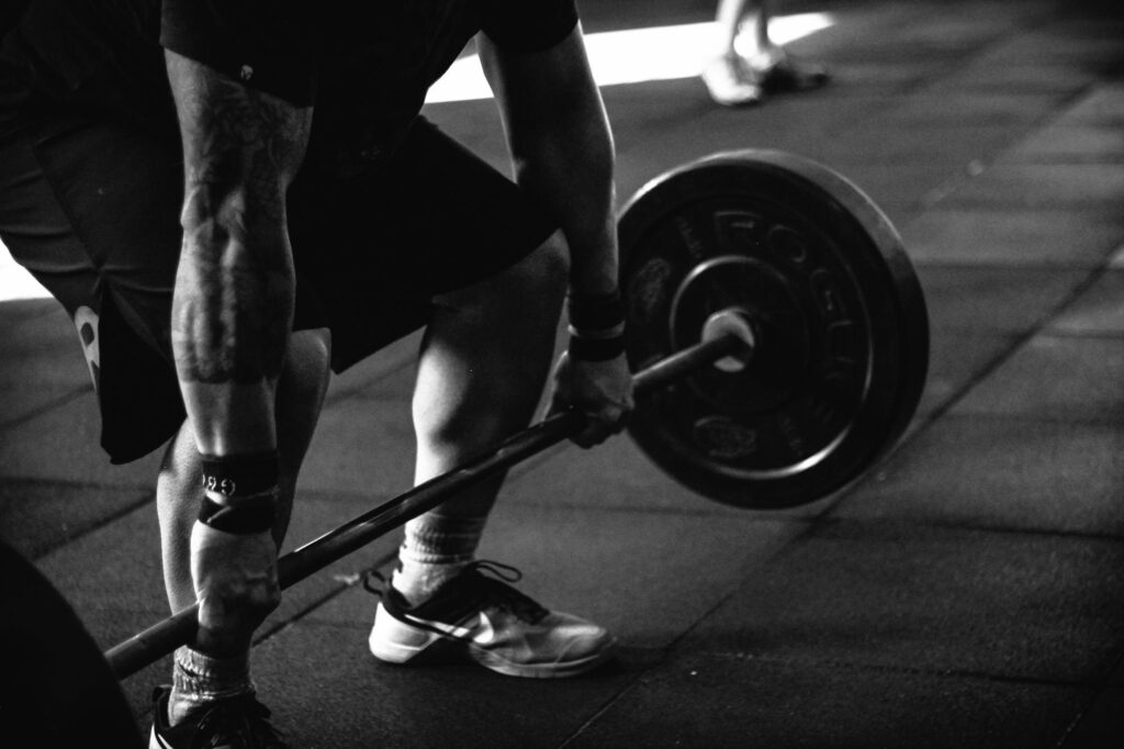 A powerful black and white image of a man deadlifting in a gym, showcasing strength and fitness.